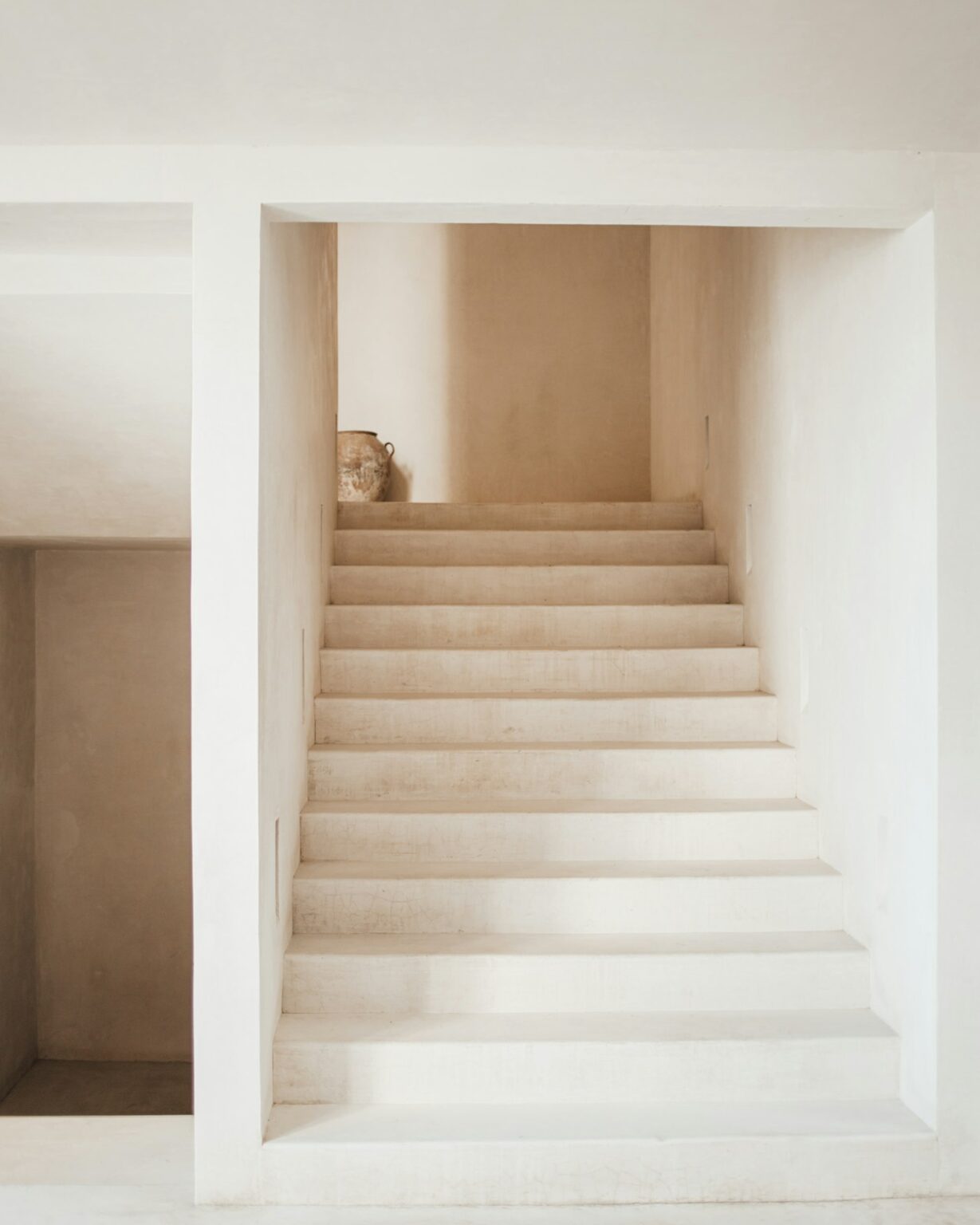 Minimal white stair lit by soft natural light