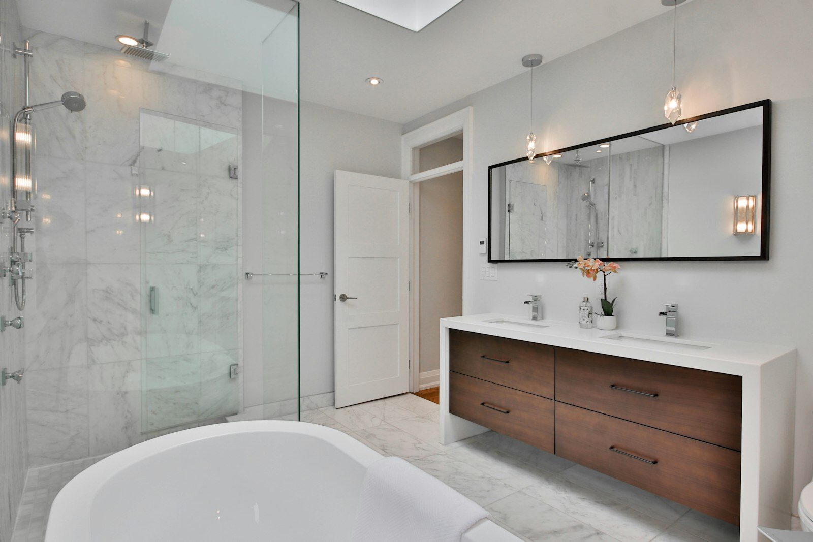 Bathroom with a white bath, marble walls and a walk-in shower
