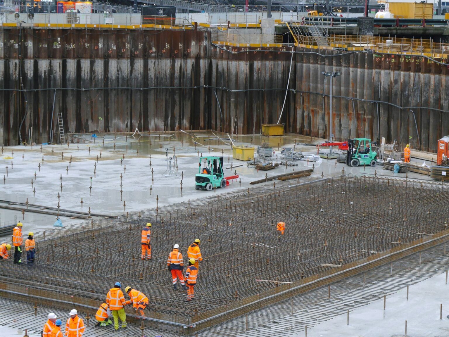 Construction team pouring a reinforced concrete slab on a large building site
