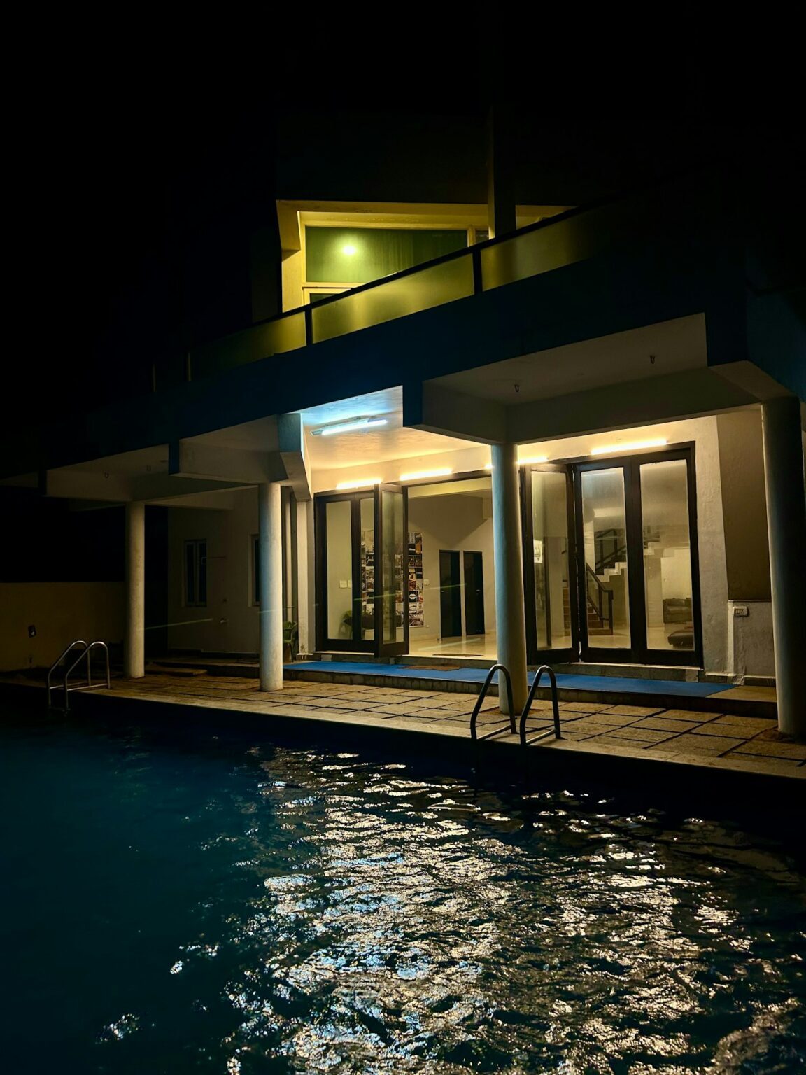 Modern house and swimming pool lit at night