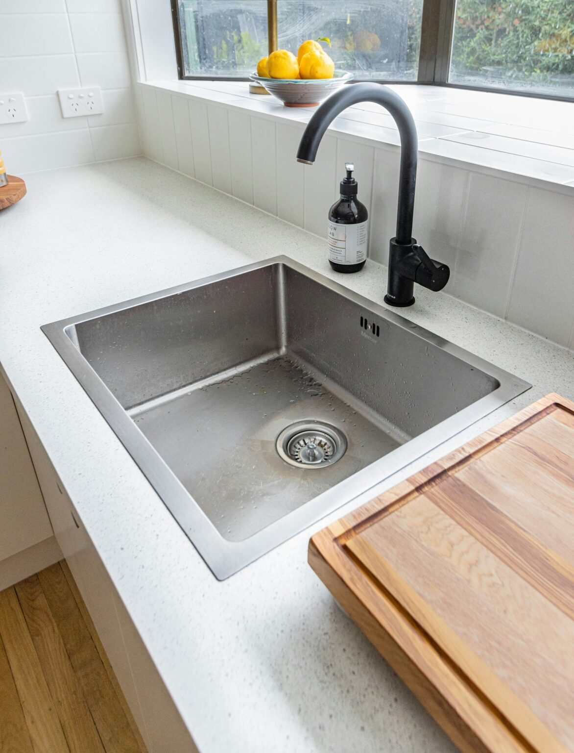 Stainless steel kitchen sink with a black tap